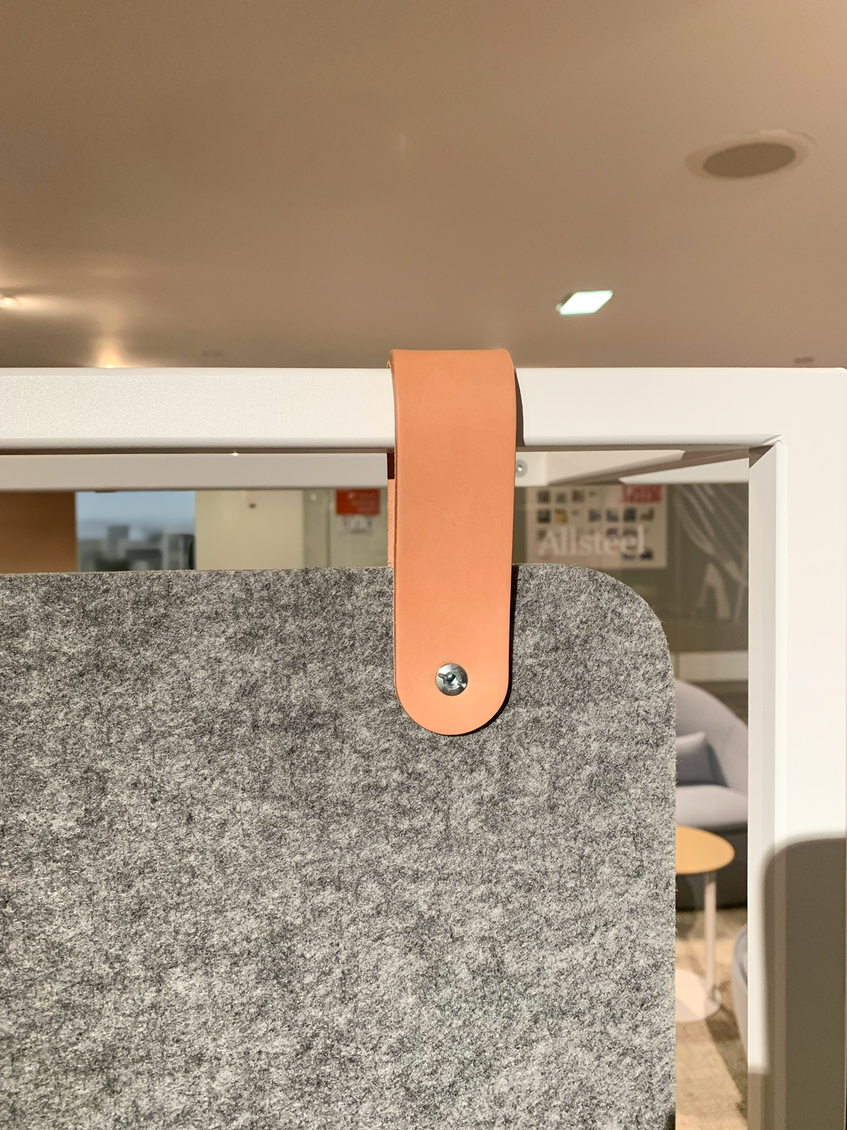 Allsteel-SantaFeStrap-Golden-leather-hang-tabs-neocon22-sm Cortina Leathers Santa Fe Strap veg-tanned leather in Golden color way is shown as used as a strap holding a room divider in place on a steel frame by Allsteel.