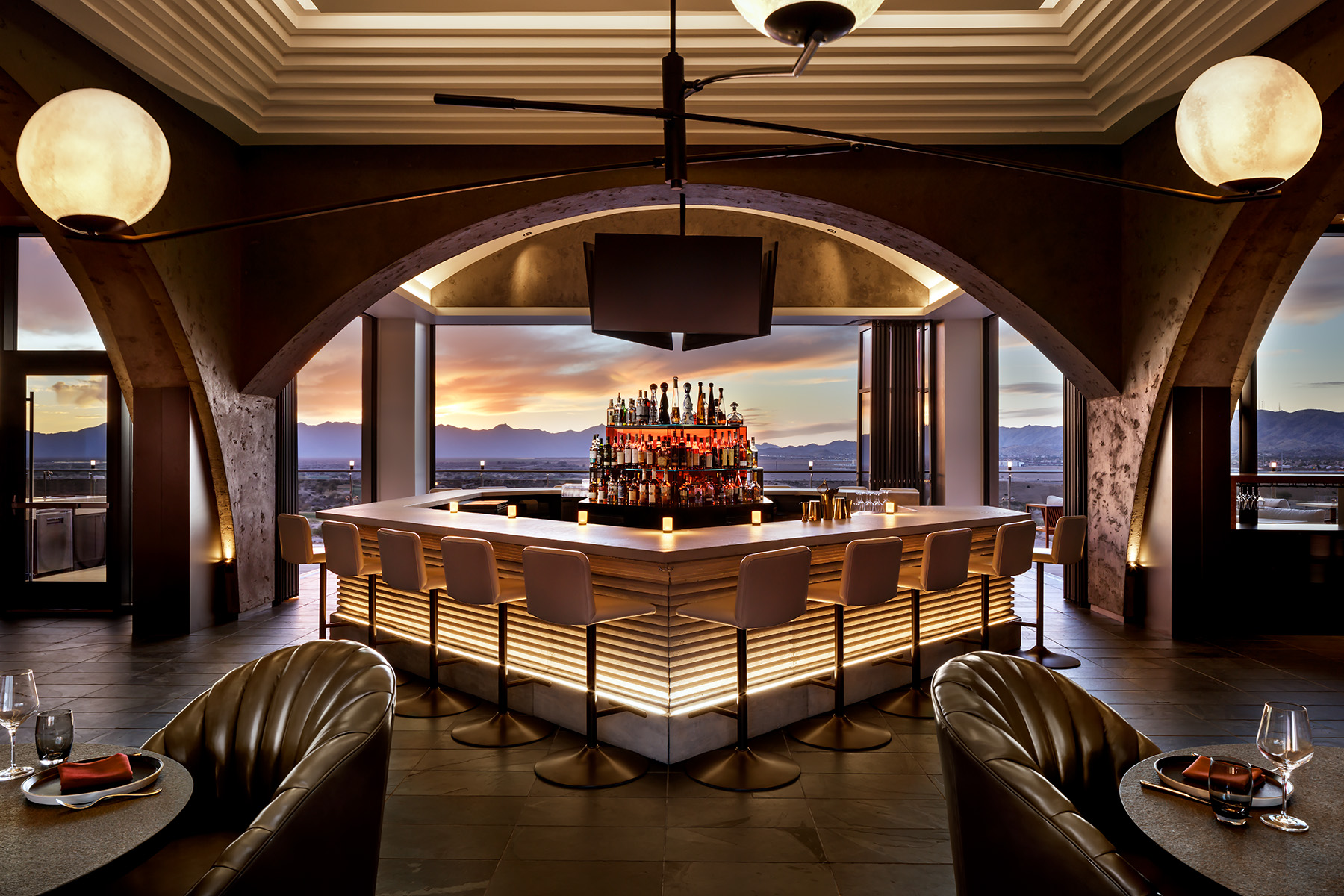 Prime Steak House in Chandler Arizona, designed by Preen, Inc. A beautiful bar and custom ceiling structure frame and unbelievable view of Arizona's where desert meets the mountains. Two Cortina leathers are featured on barstools and dining chairs.