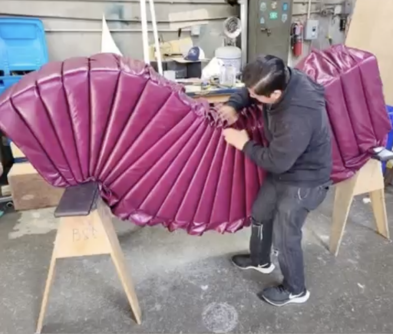 Cortina Athene Erica, a deep pink luxury genuine leather, is shown getting upholstered on a massive section of curved banquette for the VIP section in the Monroe SF